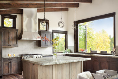 Example of a mountain style l-shaped dark wood floor eat-in kitchen design in Other with shaker cabinets, dark wood cabinets, gray backsplash, stainless steel appliances and an island