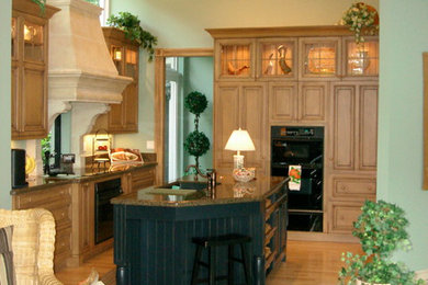 Foto de cocina clásica con fregadero bajoencimera, armarios con paneles empotrados, puertas de armario de madera oscura y encimera de granito