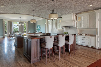 Inspiration for a huge transitional single-wall porcelain tile eat-in kitchen remodel in Tampa with a single-bowl sink, recessed-panel cabinets, white cabinets, quartzite countertops, white backsplash, stone slab backsplash, paneled appliances and two islands