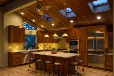Eat-in kitchen - traditional l-shaped light wood floor eat-in kitchen idea in San Francisco with an undermount sink, recessed-panel cabinets, medium tone wood cabinets, yellow backsplash, stainless steel appliances and an island
