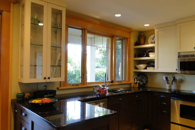 Small transitional u-shaped light wood floor enclosed kitchen photo in Vancouver with an undermount sink, shaker cabinets, medium tone wood cabinets, quartz countertops, stainless steel appliances and a peninsula