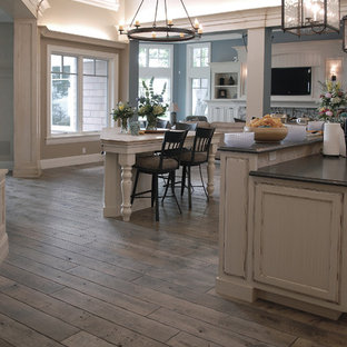 Huge coastal eat-in kitchen ideas - Example of a huge beach style u-shaped medium tone wood floor, brown floor and vaulted ceiling eat-in kitchen design in Chicago with an undermount sink, beaded inset cabinets, white cabinets, granite countertops, multicolored backsplash, ceramic backsplash, two islands and black countertops