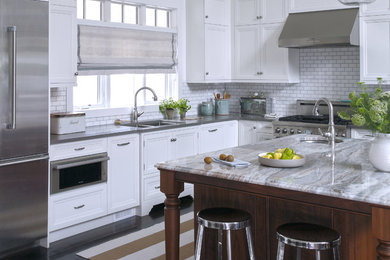 Inspiration for a large transitional l-shaped dark wood floor and brown floor kitchen remodel in Other with a double-bowl sink, recessed-panel cabinets, white cabinets, quartz countertops, white backsplash, subway tile backsplash, stainless steel appliances and an island