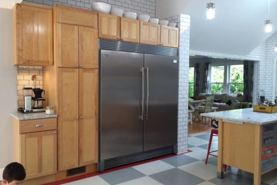 Enclosed kitchen - mid-sized eclectic l-shaped linoleum floor enclosed kitchen idea in Boston with shaker cabinets, light wood cabinets, marble countertops, white backsplash, ceramic backsplash, stainless steel appliances, an island and a farmhouse sink