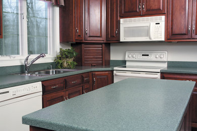 Example of a mid-sized l-shaped enclosed kitchen design in New York with a double-bowl sink, beaded inset cabinets, dark wood cabinets, quartz countertops, white backsplash, white appliances and an island