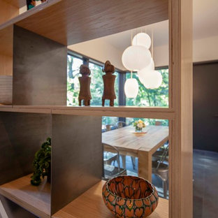 This is an example of a modern galley eat-in kitchen in Boston with white cabinets, concrete benchtops, grey splashback, with island, black floor, yellow benchtop, open cabinets, slate floors, a farmhouse sink and panelled appliances.