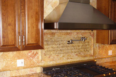 サクラメントにある広いおしゃれなキッチン (中間色木目調キャビネット、ベージュキッチンパネル、モザイクタイルのキッチンパネル、シルバーの調理設備) の写真