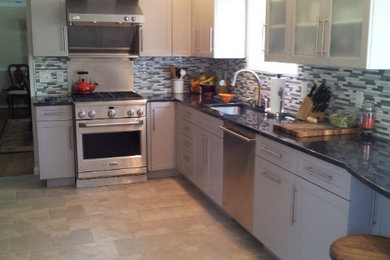 Mid-sized transitional l-shaped ceramic tile eat-in kitchen photo in Baltimore with an undermount sink, recessed-panel cabinets, white cabinets, laminate countertops, multicolored backsplash, matchstick tile backsplash, stainless steel appliances and no island