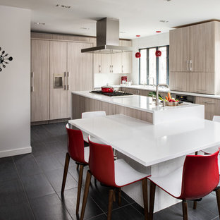 Idee per una cucina minimalista di medie dimensioni con ante lisce, top in superficie solida, elettrodomestici da incasso, ante in legno chiaro, lavello sottopiano, pavimento in gres porcellanato e pavimento nero