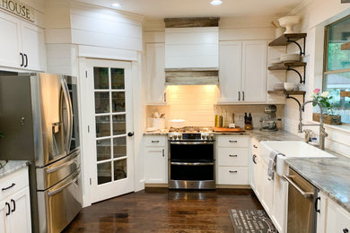 Eat-in kitchen - mid-sized cottage dark wood floor and brown floor eat-in kitchen idea in Austin with a farmhouse sink, white cabinets, granite countertops, white backsplash, ceramic backsplash, stainless steel appliances, an island and gray countertops