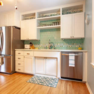 Photo of a midcentury separate kitchen in Minneapolis with an undermount sink, shaker cabinets, white cabinets, recycled glass benchtops, green splashback, mosaic tile splashback, stainless steel appliances, medium hardwood floors, no island, brown floor and white benchtop.