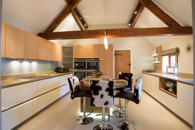 This is an example of a large rustic u-shaped kitchen in West Midlands with flat-panel cabinets, white cabinets, wood worktops, an island, beige floors, blue splashback and beige worktops.