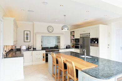 Inspiration för stora klassiska grått u-kök, med luckor med infälld panel, beige skåp, en köksö och beiget golv