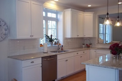Eat-in kitchen - large contemporary u-shaped light wood floor eat-in kitchen idea in Boston with a double-bowl sink, raised-panel cabinets, white cabinets, marble countertops, white backsplash, subway tile backsplash, stainless steel appliances and an island