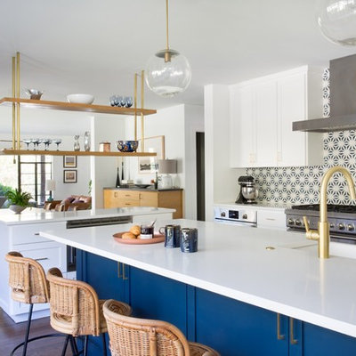 Open concept kitchen - eclectic dark wood floor and brown floor open concept kitchen idea in Austin with a farmhouse sink, shaker cabinets, blue cabinets, multicolored backsplash, mosaic tile backsplash, stainless steel appliances and two islands