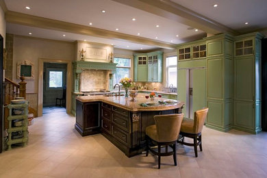 Eat-in kitchen - large transitional l-shaped ceramic tile and beige floor eat-in kitchen idea in Calgary with an undermount sink, raised-panel cabinets, green cabinets, granite countertops, beige backsplash, ceramic backsplash, paneled appliances and an island