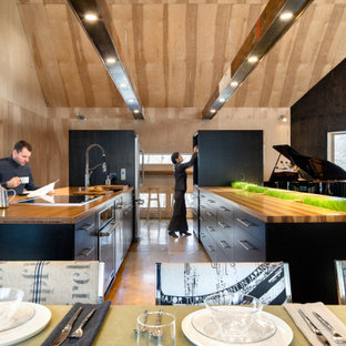 Inspiration for a large modern open plan kitchen in Boston with an undermount sink, flat-panel cabinets, black cabinets, wood benchtops, stainless steel appliances, plywood floors and multiple islands.