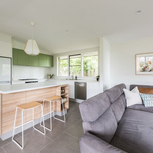 Photo of a mid-sized contemporary u-shaped open plan kitchen in Melbourne with flat-panel cabinets, white cabinets, white splashback, with island, grey floor, a double-bowl sink, quartz benchtops, ceramic splashback, stainless steel appliances, porcelain floors and grey benchtop.