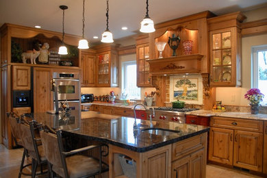 Large elegant l-shaped ceramic tile and brown floor eat-in kitchen photo in Other with an undermount sink, raised-panel cabinets, medium tone wood cabinets, granite countertops, multicolored backsplash, ceramic backsplash, paneled appliances and an island