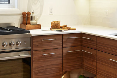 Inspiration for a mid-sized modern u-shaped light wood floor eat-in kitchen remodel in Toronto with a single-bowl sink, flat-panel cabinets, medium tone wood cabinets, quartz countertops, white backsplash, ceramic backsplash, stainless steel appliances and a peninsula