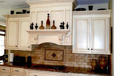 Inredning av ett klassiskt stort kök, med en köksö, luckor med upphöjd panel, vita skåp, granitbänkskiva, beige stänkskydd, stänkskydd i tunnelbanekakel, integrerade vitvaror, en nedsänkt diskho och mörkt trägolv