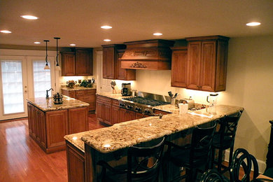 Example of a large classic l-shaped medium tone wood floor eat-in kitchen design in Charlotte with a double-bowl sink, shaker cabinets, medium tone wood cabinets, granite countertops, stainless steel appliances and an island