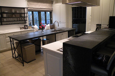 Example of a large minimalist galley slate floor eat-in kitchen design in Charlotte with a double-bowl sink, raised-panel cabinets, white cabinets, stainless steel appliances, an island, white backsplash, subway tile backsplash and soapstone countertops