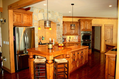 Immagine di un cucina con isola centrale american style con lavello stile country, ante in legno scuro, elettrodomestici in acciaio inossidabile e parquet scuro