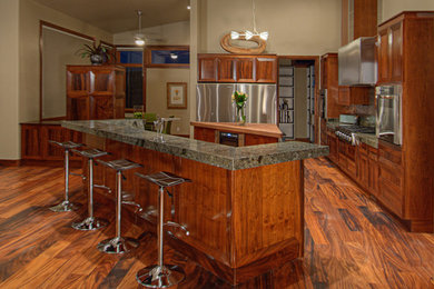 Example of a large arts and crafts l-shaped dark wood floor and brown floor eat-in kitchen design in Salt Lake City with shaker cabinets, medium tone wood cabinets, granite countertops, brown backsplash, mosaic tile backsplash, stainless steel appliances, two islands and an undermount sink