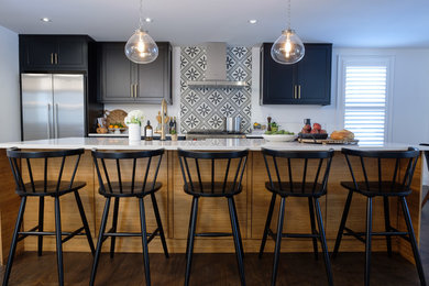 Example of a mid-sized minimalist single-wall dark wood floor and brown floor eat-in kitchen design in Toronto with a farmhouse sink, shaker cabinets, black cabinets, quartzite countertops, black backsplash, ceramic backsplash, stainless steel appliances, an island and white countertops