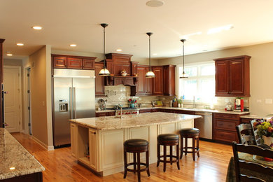 Rustikale Wohnküche in L-Form mit dunklen Holzschränken, Küchengeräten aus Edelstahl, Kücheninsel, Waschbecken, braunem Holzboden und braunem Boden in Chicago