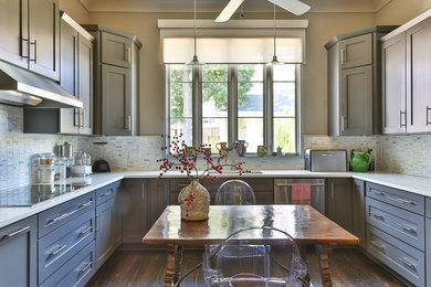 Example of a mid-sized transitional u-shaped dark wood floor and brown floor enclosed kitchen design in New Orleans with an undermount sink, shaker cabinets, gray cabinets, quartz countertops, multicolored backsplash, porcelain backsplash, paneled appliances, no island and white countertops