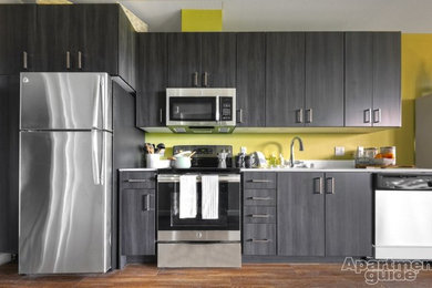 Inspiration for a small contemporary single-wall vinyl floor open concept kitchen remodel in Seattle with an undermount sink, flat-panel cabinets, gray cabinets, quartzite countertops, white backsplash, stainless steel appliances and no island