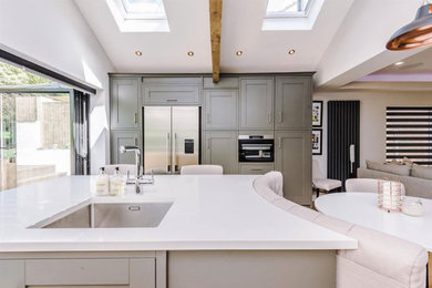 Design ideas for a large modern single-wall kitchen in West Midlands with a submerged sink, shaker cabinets, green cabinets, quartz worktops, stainless steel appliances, an island and white worktops.