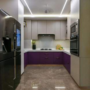 Foto di una cucina ad U design di medie dimensioni con ante lisce, ante viola, paraspruzzi grigio, elettrodomestici neri, nessuna isola, pavimento marrone e top bianco