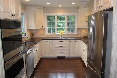 Enclosed kitchen - mid-sized traditional u-shaped dark wood floor enclosed kitchen idea in New York with a single-bowl sink, raised-panel cabinets, white cabinets, quartz countertops, beige backsplash, stainless steel appliances and no island