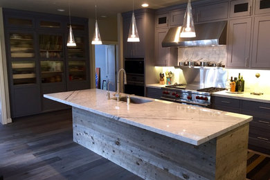 Example of a large trendy u-shaped dark wood floor and brown floor eat-in kitchen design in San Francisco with shaker cabinets, gray cabinets, marble countertops, gray backsplash, stainless steel appliances and an island