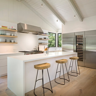 Large mid-century modern kitchen inspiration - Example of a large 1960s l-shaped light wood floor and beige floor kitchen design in Other with open cabinets, white backsplash, stainless steel appliances, an island, an undermount sink, white cabinets and quartz countertops