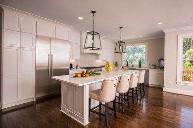 Eat-in kitchen - large transitional l-shaped dark wood floor eat-in kitchen idea in DC Metro with a farmhouse sink, shaker cabinets, white cabinets, beige backsplash, stainless steel appliances, an island, quartz countertops and porcelain backsplash