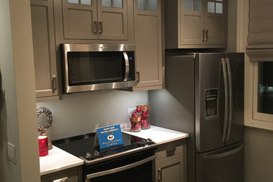 Example of a small transitional galley vinyl floor and multicolored floor eat-in kitchen design in Other with a double-bowl sink, shaker cabinets, gray cabinets, quartzite countertops, stainless steel appliances, a peninsula and white countertops