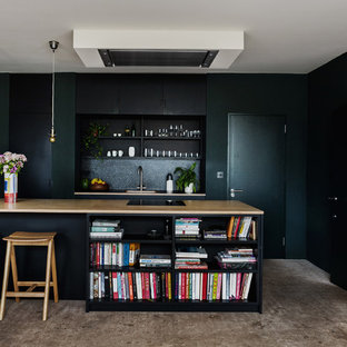 Inspiration for a medium sized traditional kitchen in London with flat-panel cabinets, black cabinets, wood worktops, black splashback, concrete flooring, an island, grey floors and a single-bowl sink.