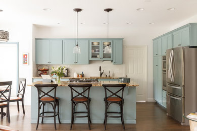 Inspiration for a mid-sized coastal dark wood floor and brown floor open concept kitchen remodel in Portland with shaker cabinets, blue cabinets, granite countertops, white backsplash, stainless steel appliances, an island, subway tile backsplash and brown countertops