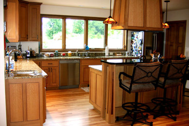 Example of a mountain style l-shaped eat-in kitchen design in Other with flat-panel cabinets, medium tone wood cabinets, granite countertops, terra-cotta backsplash and an island