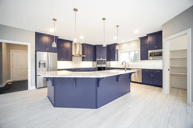 Example of a large trendy l-shaped kitchen pantry design in Chicago with blue cabinets, gray backsplash, an island and gray countertops