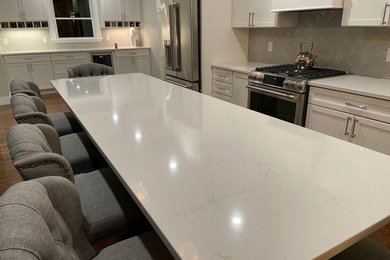 Transitional kitchen photo in Boston with quartz countertops, gray backsplash, ceramic backsplash, stainless steel appliances, an island and white countertops