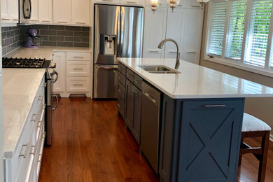 Kitchen - traditional medium tone wood floor kitchen idea in Atlanta with a drop-in sink, shaker cabinets, white cabinets, quartz countertops, gray backsplash, subway tile backsplash, stainless steel appliances, an island and gray countertops