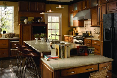 Example of a large l-shaped enclosed kitchen design in Boston with a drop-in sink, recessed-panel cabinets, medium tone wood cabinets, beige backsplash, ceramic backsplash, stainless steel appliances and an island