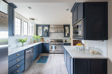Transitional u-shaped gray floor kitchen photo in Seattle with an undermount sink, shaker cabinets, blue cabinets, white backsplash, mosaic tile backsplash, stainless steel appliances and white countertops