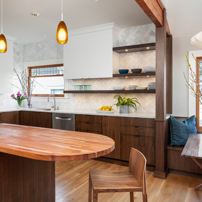 Example of a mid-sized 1950s l-shaped medium tone wood floor eat-in kitchen design in Seattle with quartz countertops, white backsplash, stone tile backsplash, stainless steel appliances, a double-bowl sink, dark wood cabinets, an island and flat-panel cabinets