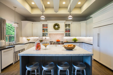 Eat-in kitchen - large transitional u-shaped porcelain tile eat-in kitchen idea in Phoenix with a farmhouse sink, shaker cabinets, white cabinets, marble countertops, gray backsplash, stone tile backsplash, paneled appliances and an island